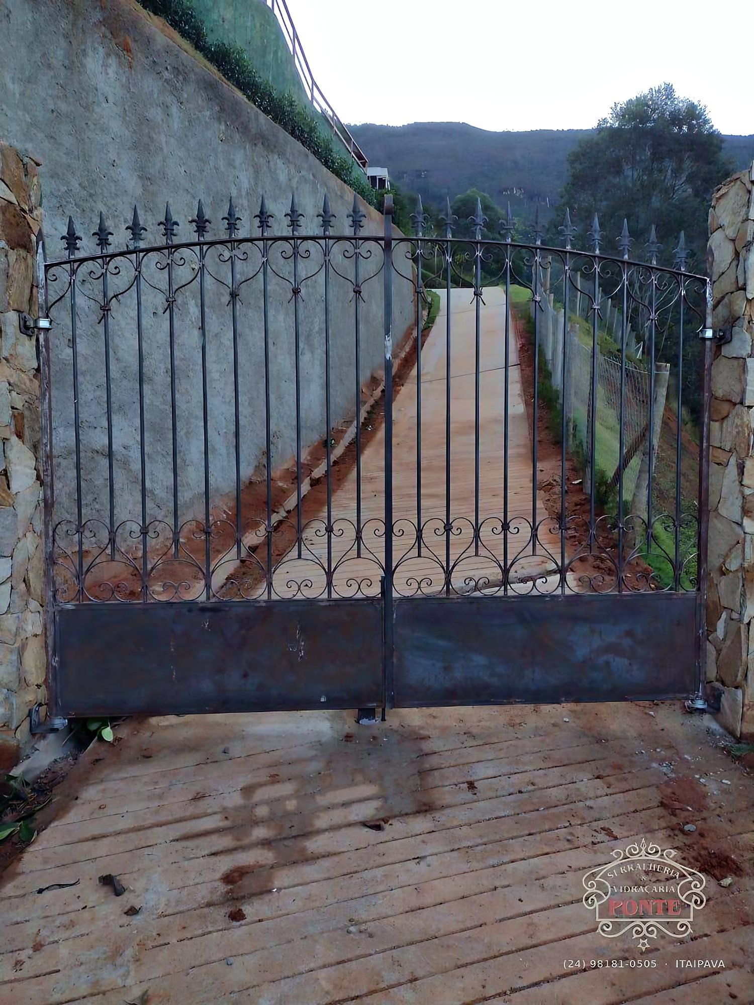 Portão pivotante em ferro batido com ornatos e lanças